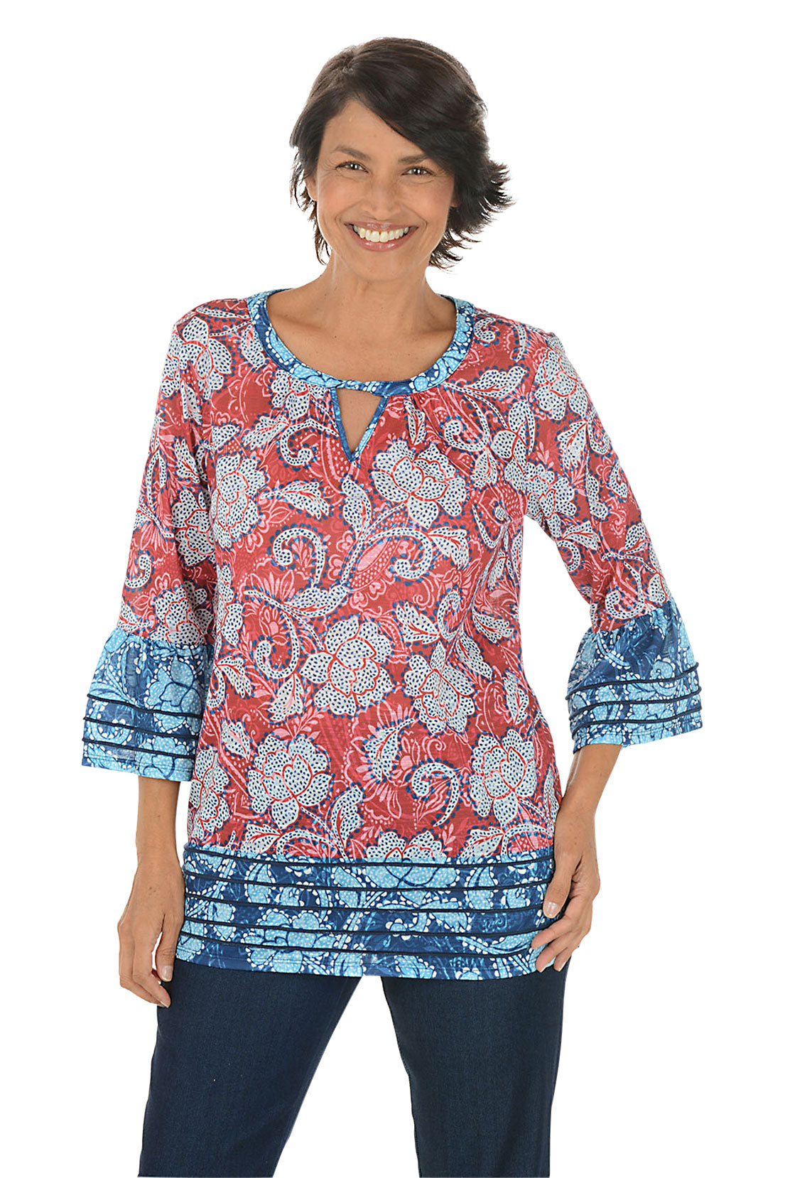 Woman wearing a patterned blouse with red and blue design on a white background.