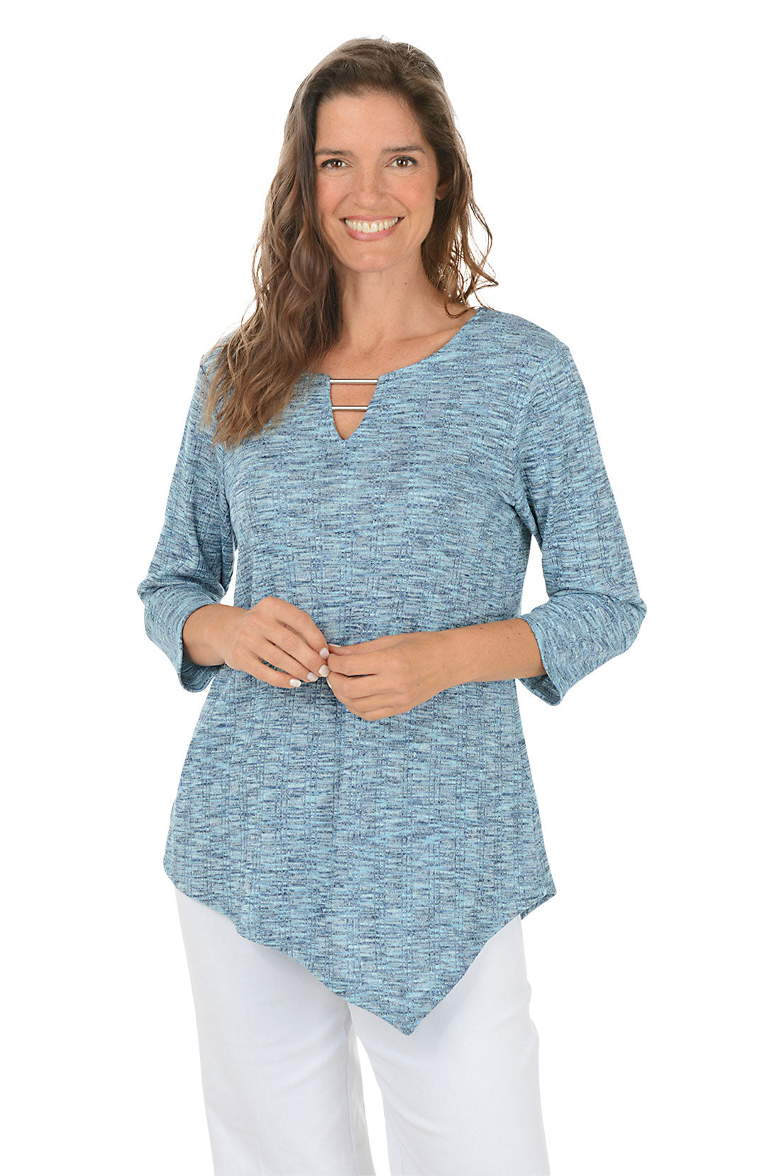 Woman wearing a blue knit top with an asymmetrical handkerchief hemline on white background.