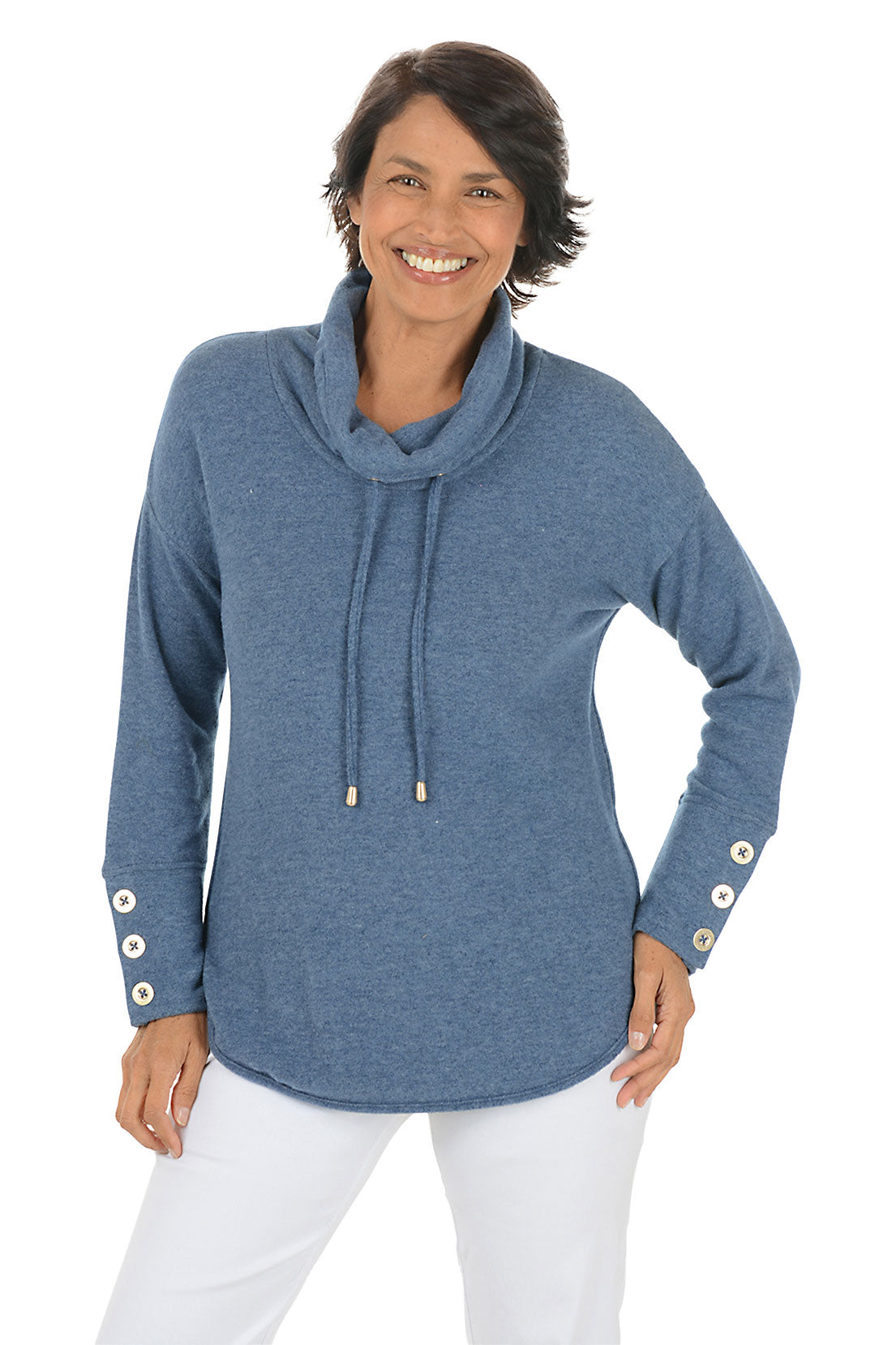 Woman wearing a blue cowl-neck sweater with white pants on a white background. Second front shot.