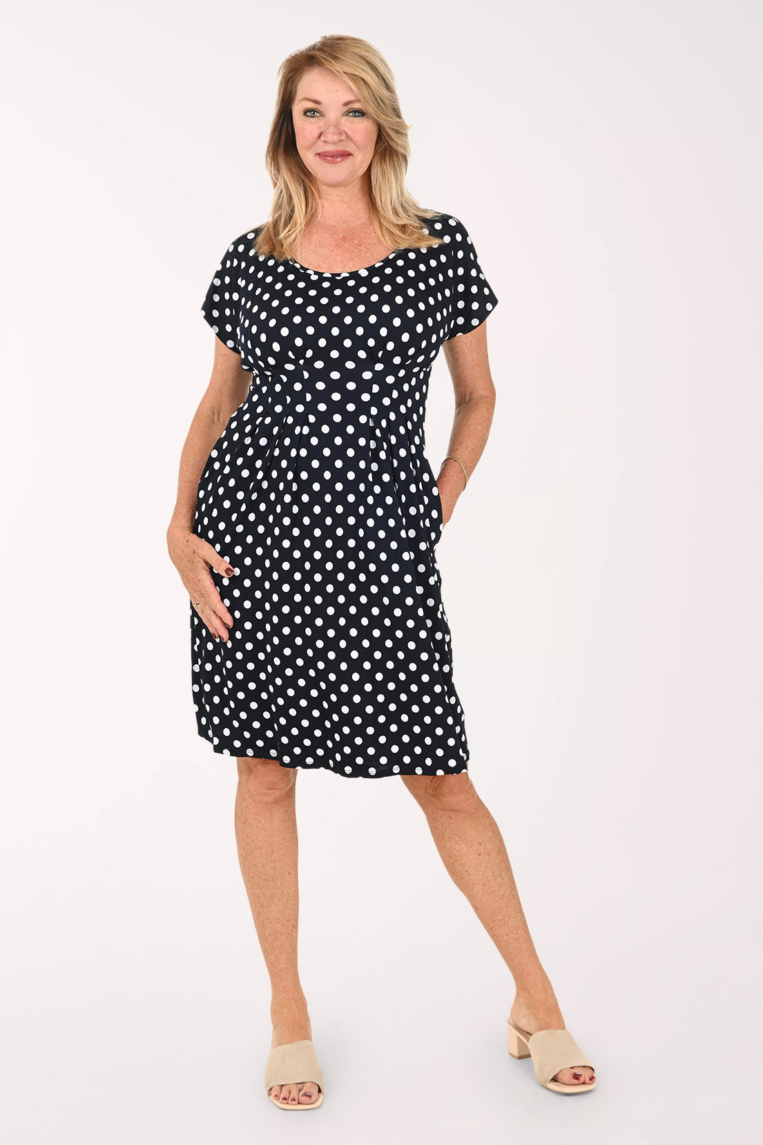 Woman wearing a short sleeve navy and white polka dot dress 