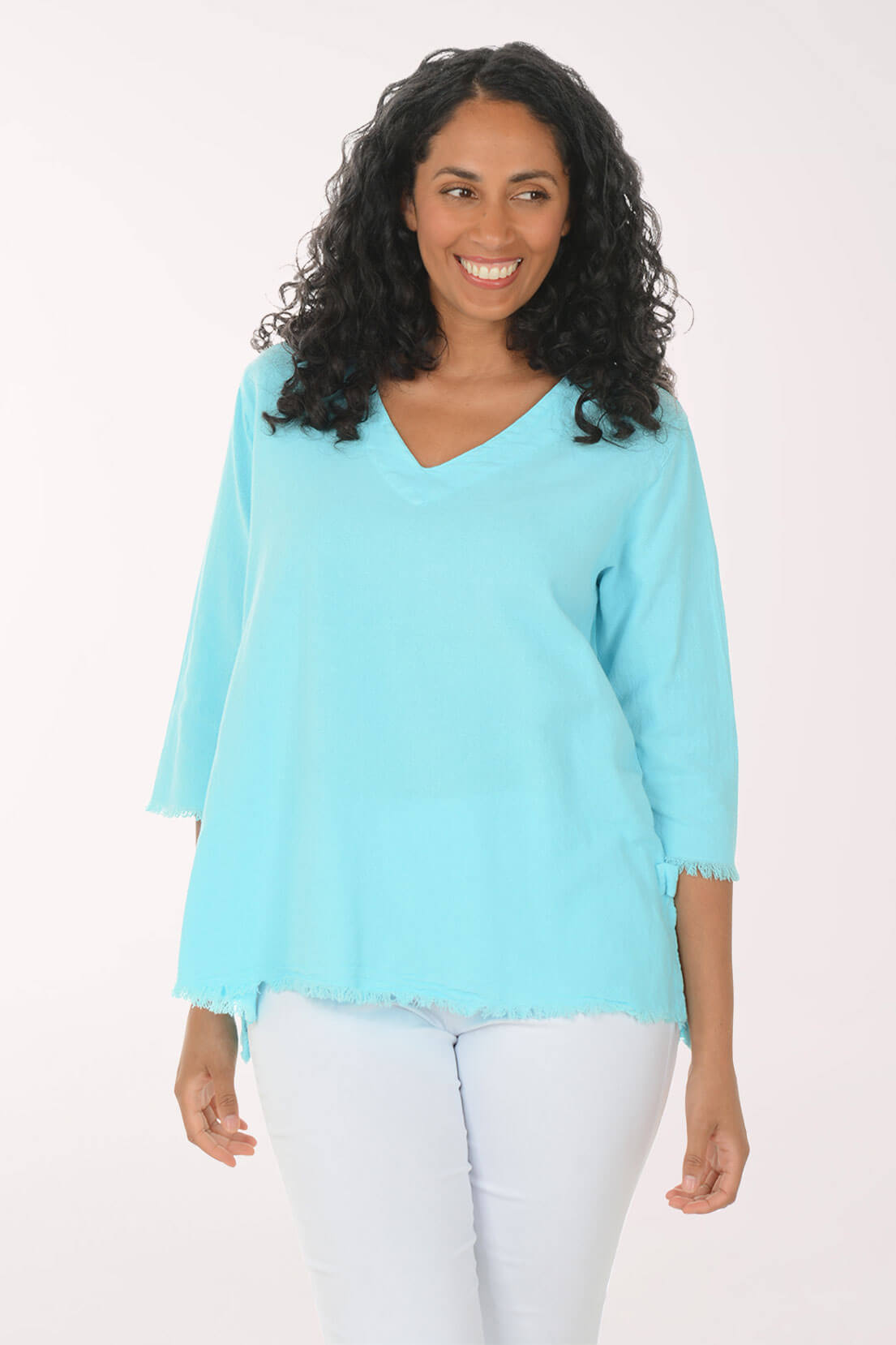 Woman wearing a light blue top and white pants on a white background