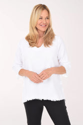 Woman wearing a white sweater and black pants on a white background