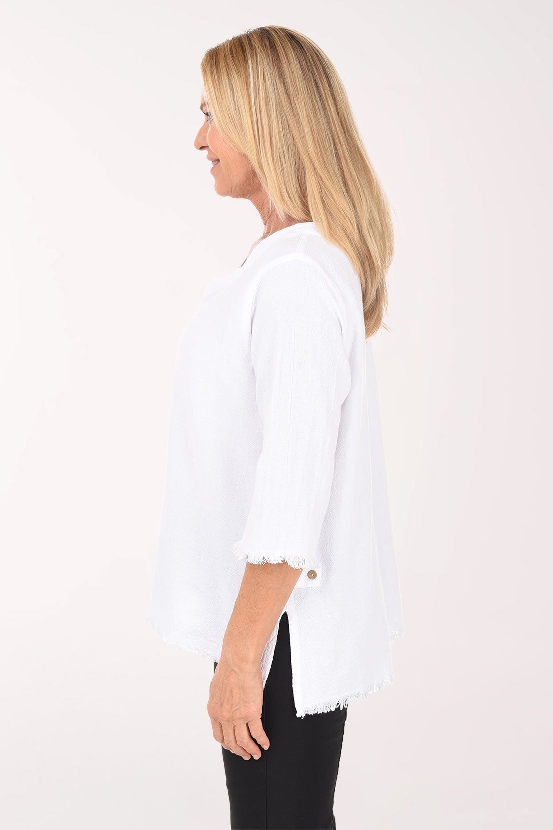 Woman wearing a white sweater and black pants on a white background