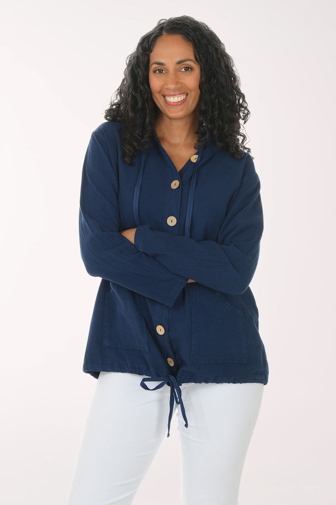 Woman wearing a navy blue cardigan with gold buttons on a white background