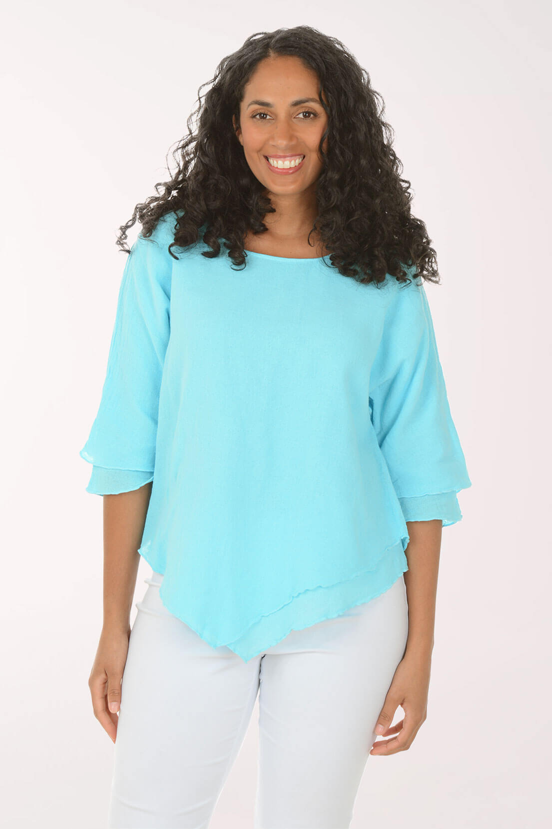 Woman wearing a light blue top and white pants on a white background