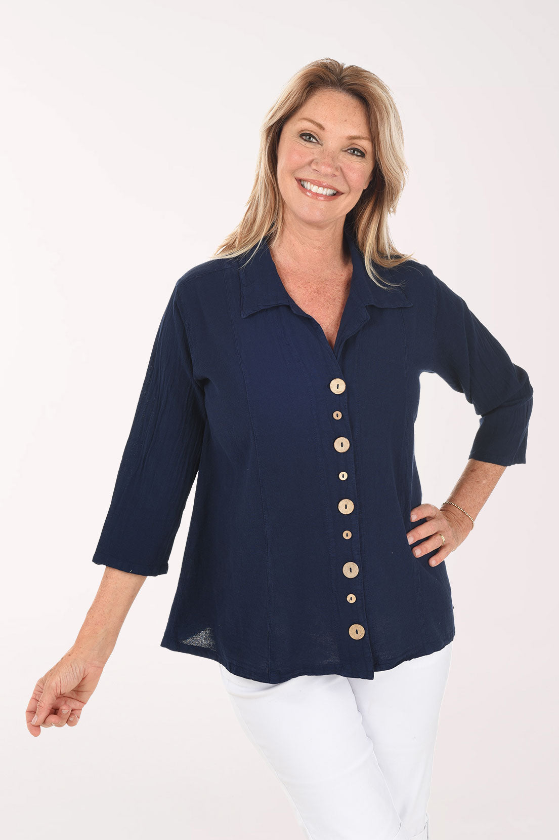 Woman wearing a navy blue button-up shirt with a white background