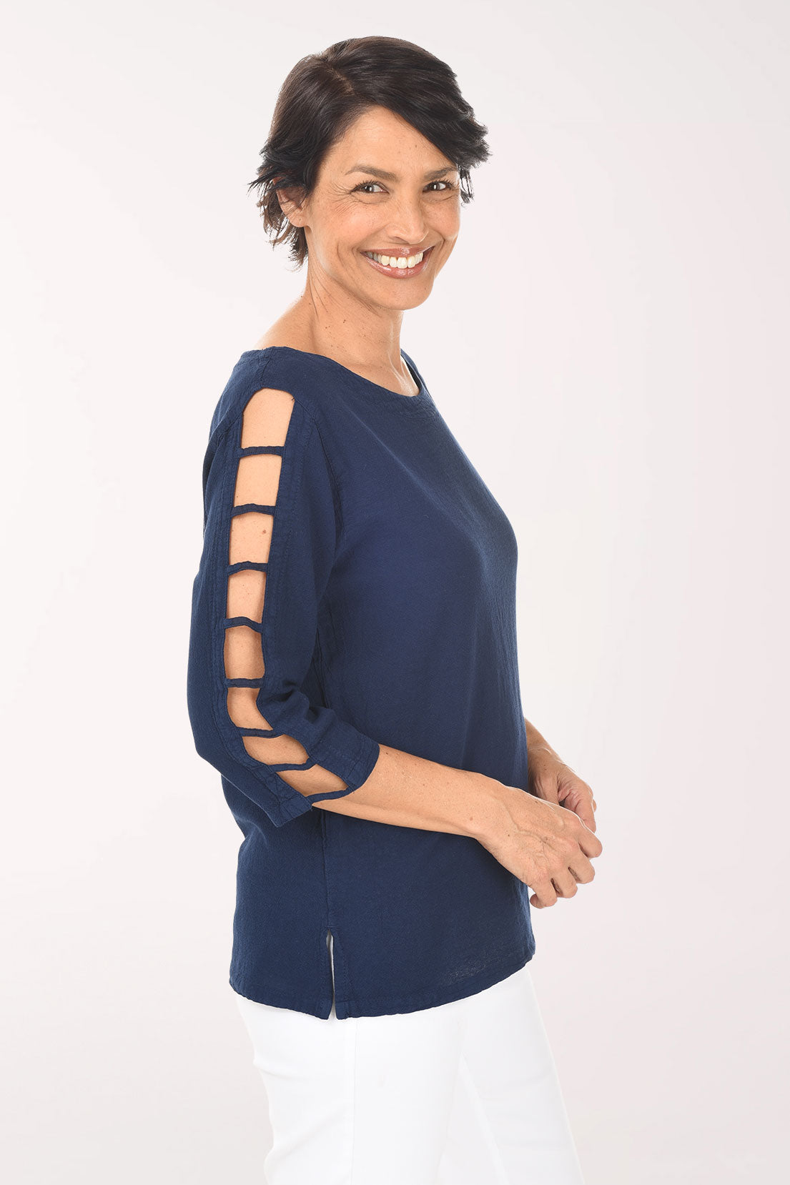 Woman wearing a navy blue top with cut-out sleeves on a white background
