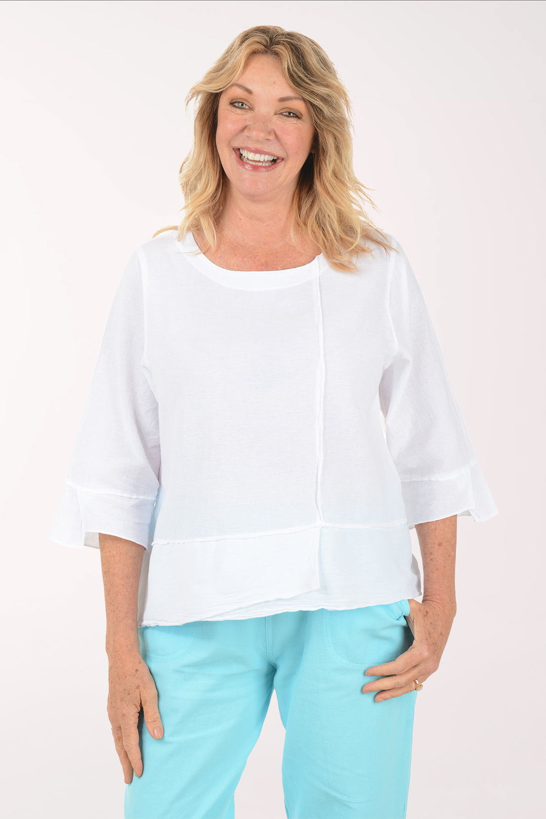 A woman wearing a 3/4 sleeve white blouse.