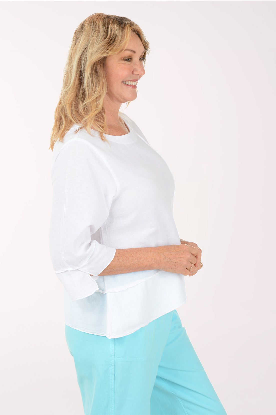 A woman wearing a 3/4 sleeve white blouse.