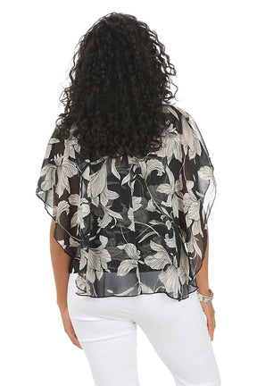 Woman wearing a floral blouse and white pants on a white background. Back shot.
