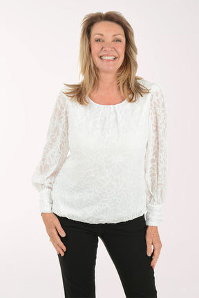 Woman wearing a white lace top and black pants on a white background