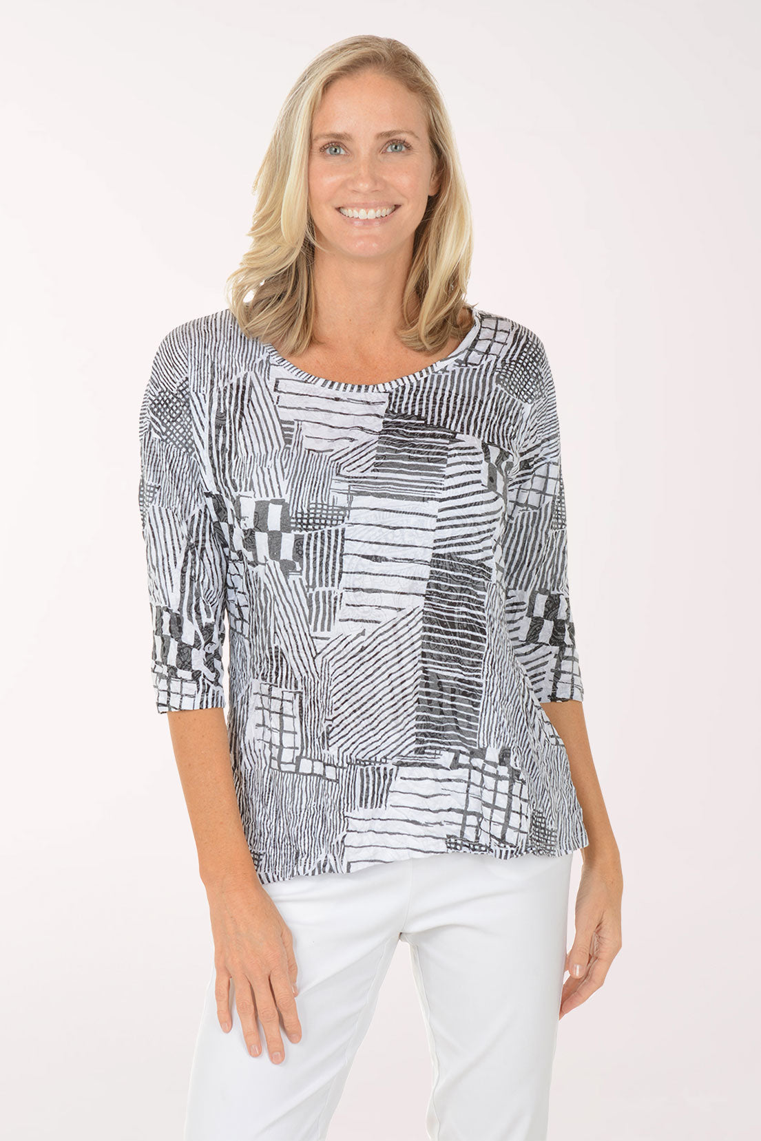 Woman wearing a black and white patterned top on a white background