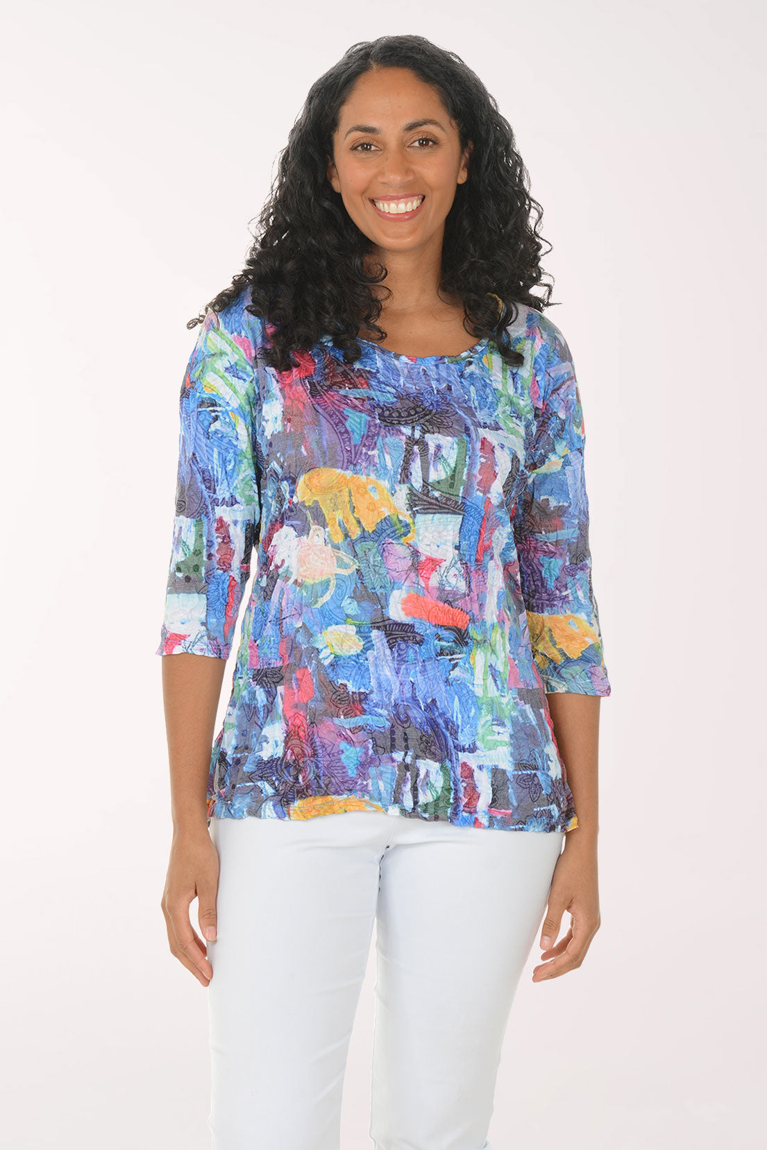 Woman wearing a colorful floral print top against a white background