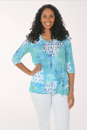 Woman wearing a colorful patterned top on a white background