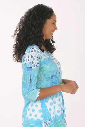 Woman wearing a colorful patterned top on a white background