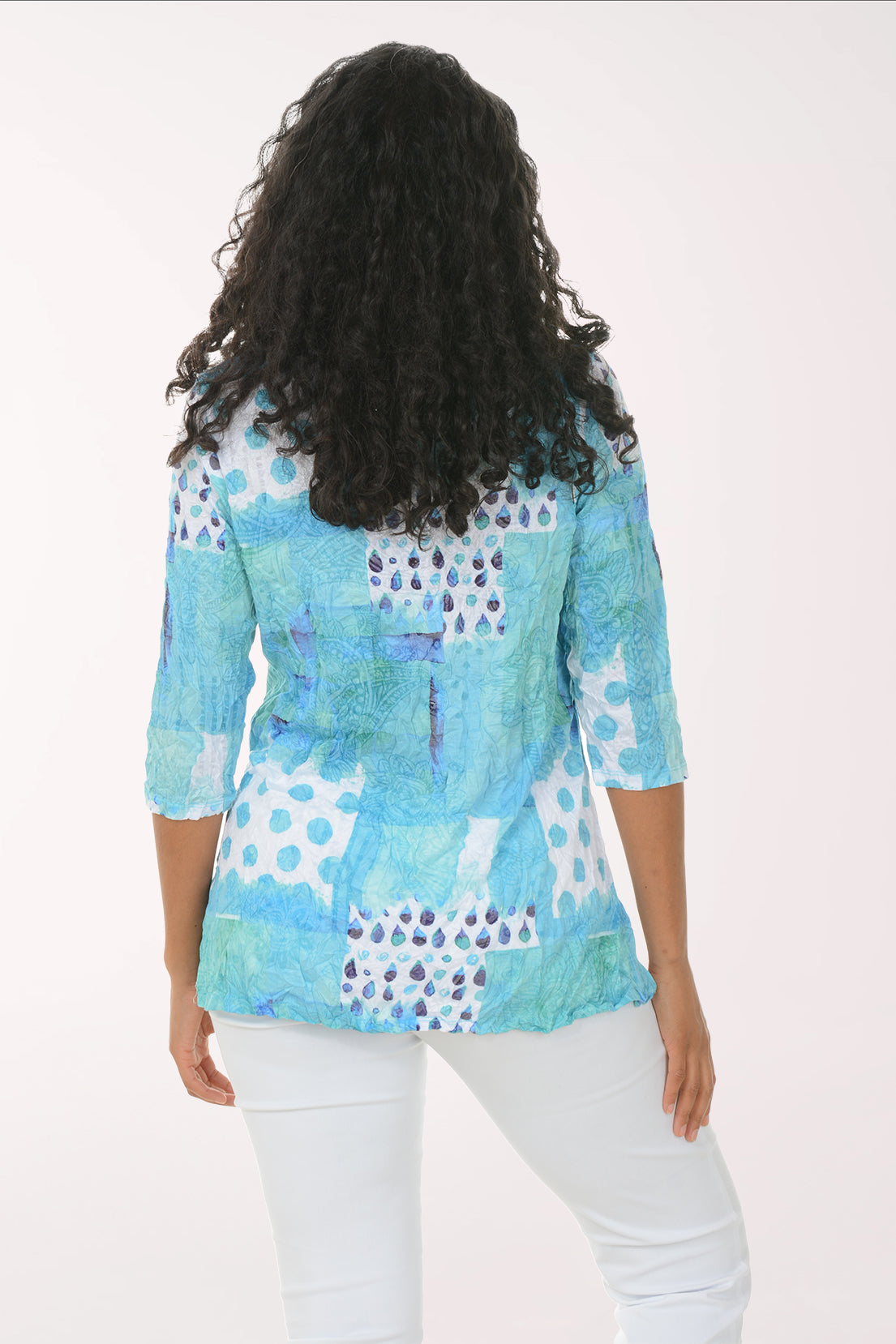 Woman wearing a colorful patterned top on a white background