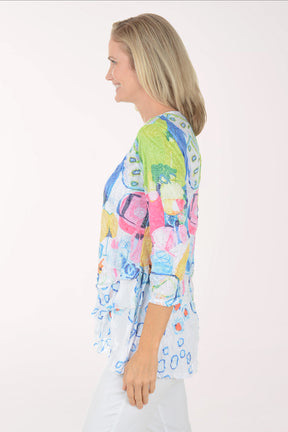 Woman wearing a colorful patterned top on a white background