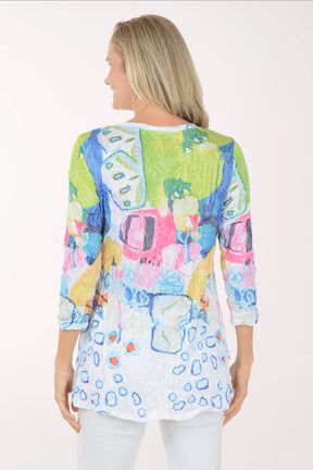 Woman wearing a colorful patterned top on a white background