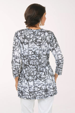 Woman wearing a black and white patterned top with 3/4 sleeves.