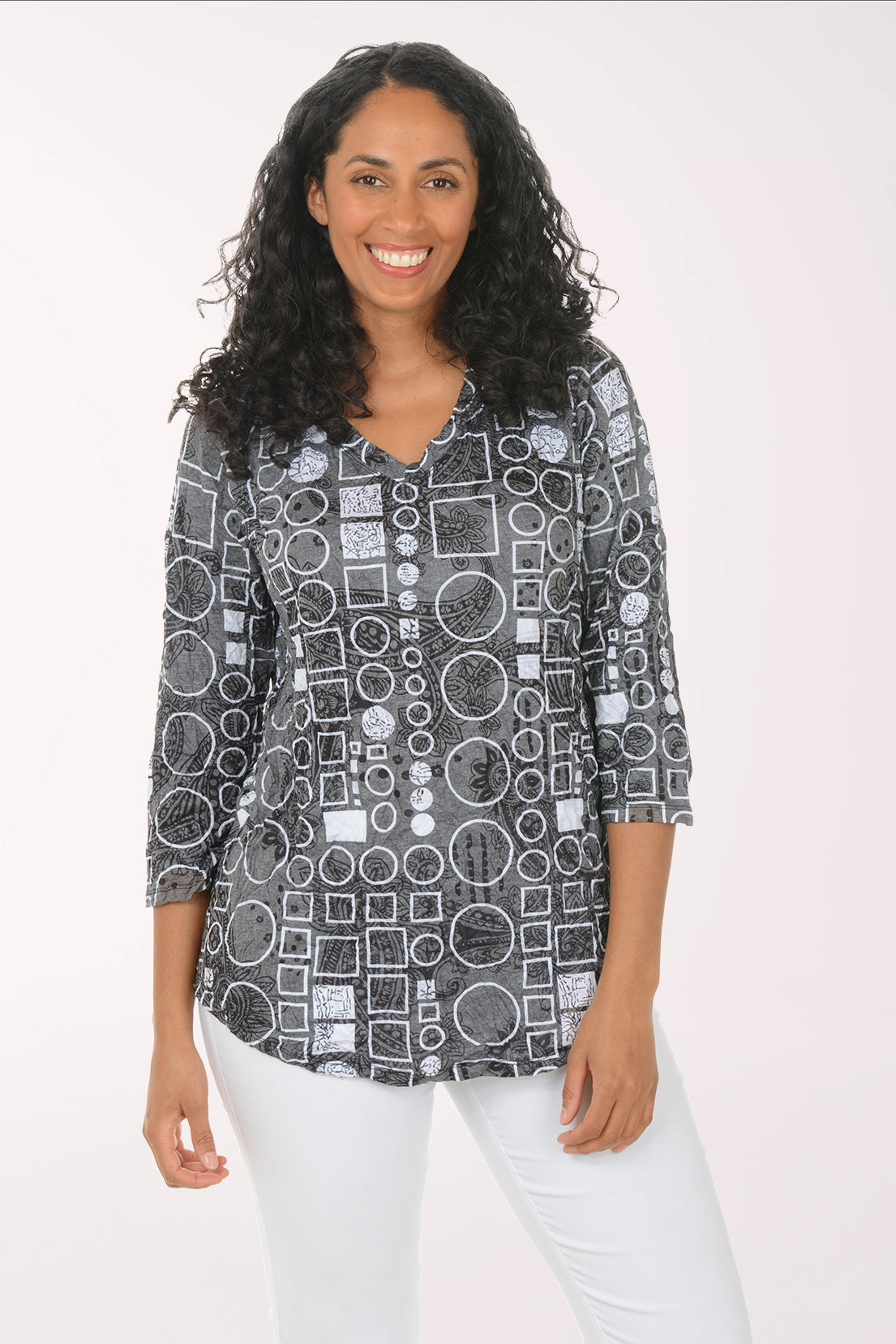 Woman wearing a patterned shirt with geometric design on a white background