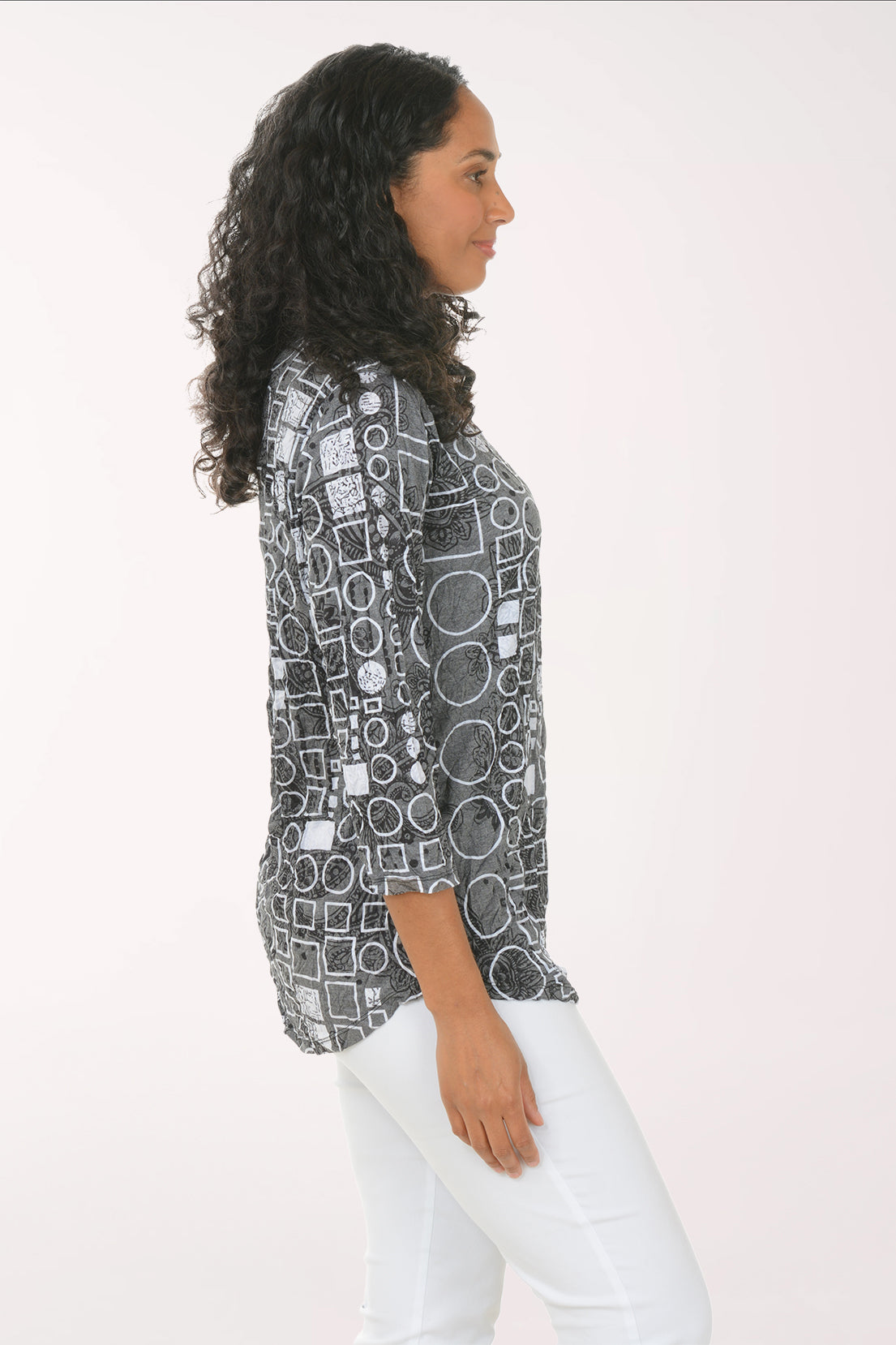 Woman wearing a patterned shirt with geometric design on a white background