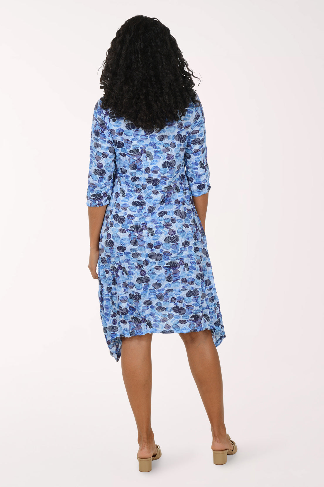 Woman wearing a blue floral dress on a white background