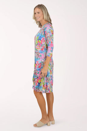 Woman wearing a colorful floral dress on a white background