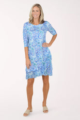 Woman wearing a blue floral dress on a white background
