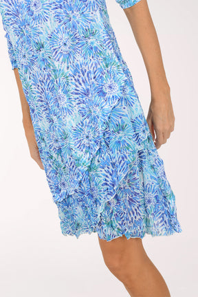Woman wearing a blue floral dress on a white background