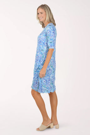 Woman wearing a blue floral dress on a white background