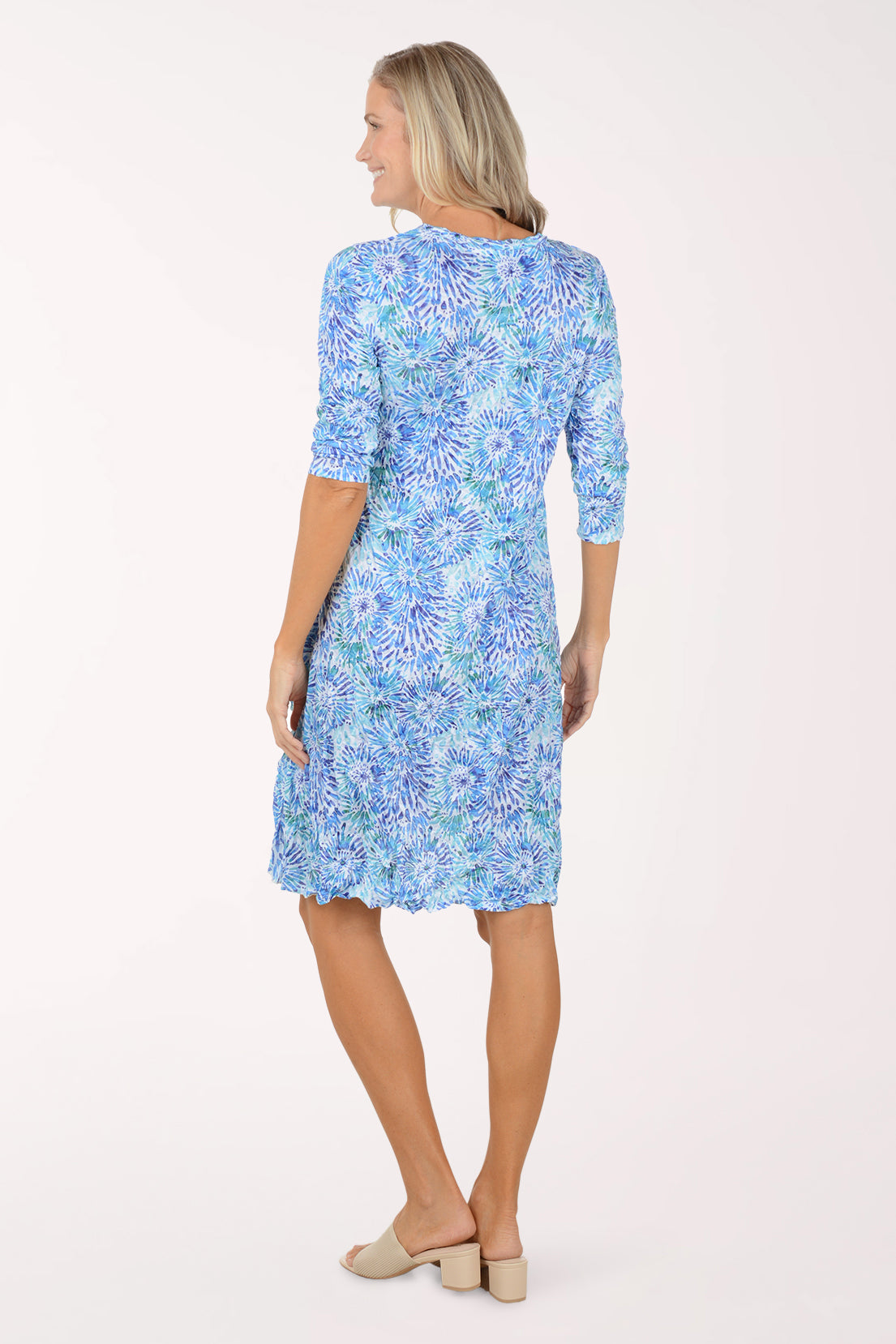 Woman wearing a blue floral dress on a white background