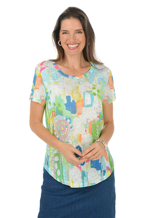 Woman wearing a colorful patterned shirt with a white background.
