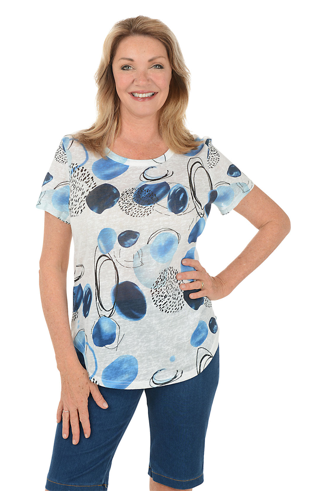 Woman wearing a blue and white patterned top with denim shorts on a white background