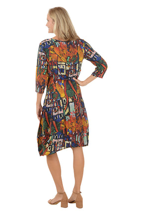 A woman wearing a 3/4 sleeve dress with a multi-colored patterned. Back shot.