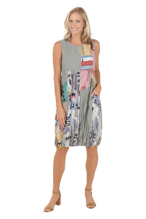 A woman wearing a grey sleeveless dress with a multi color pattered and left hip pocket.