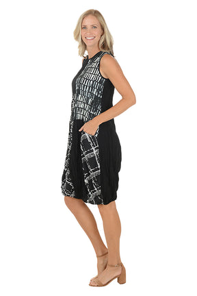 Woman wearing a black and white sleeveless dress with a left hip pocket.  Side shot.