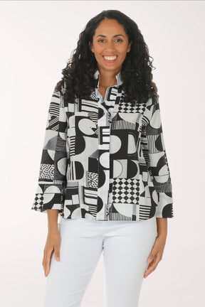 Woman wearing a black and white geometric patterned shirt against a white background