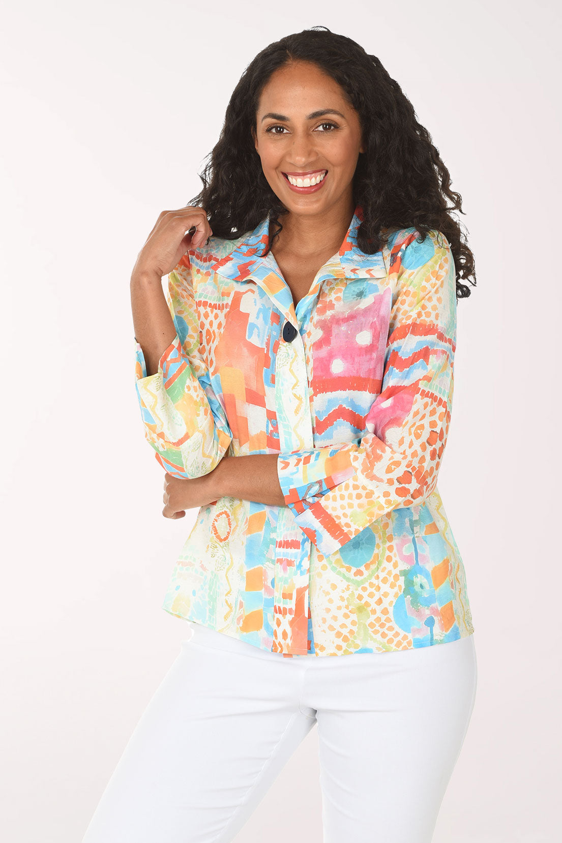 Woman wearing a colorful patterned shirt against a white background