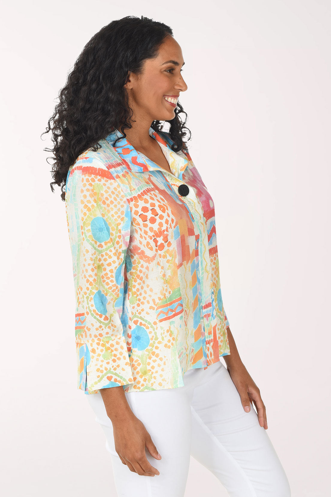 Woman wearing a colorful patterned shirt against a white background