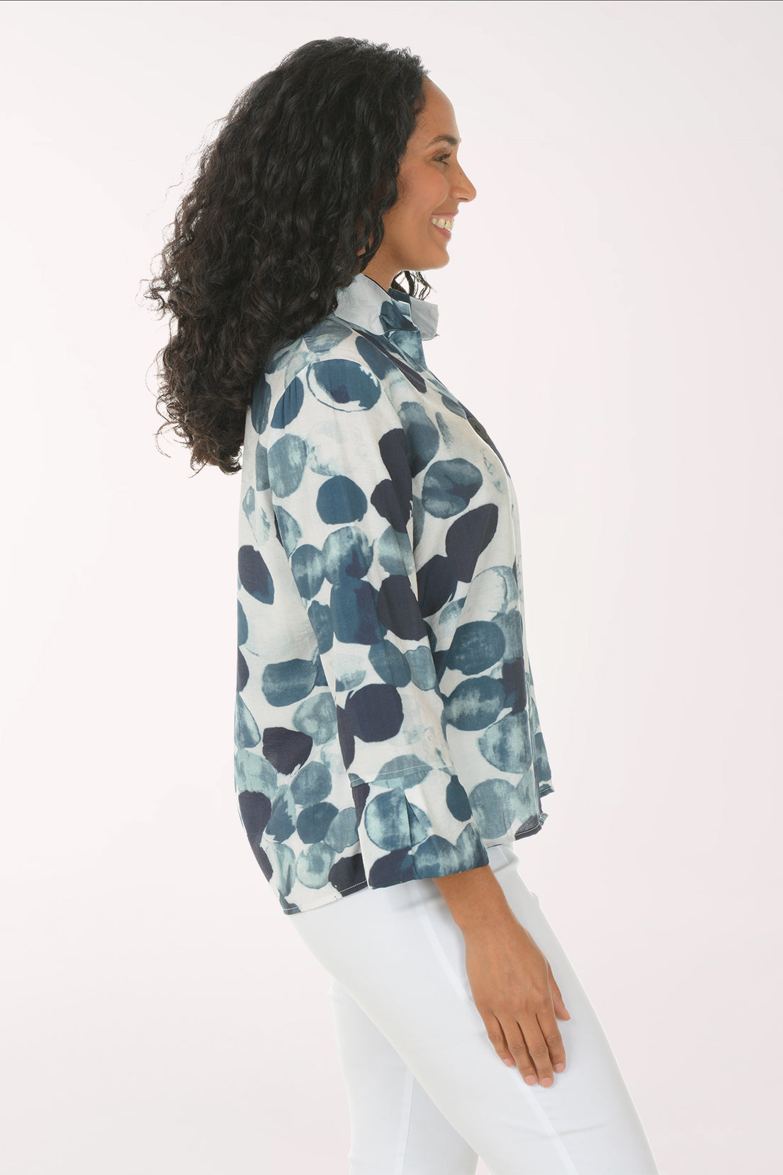 Woman wearing a blue and white floral patterned shirt on a white background
