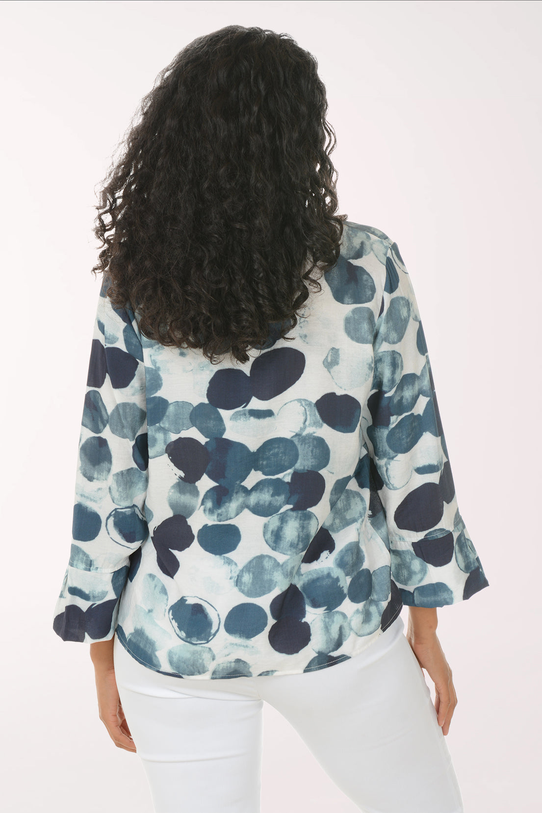 Woman wearing a navy button down with a dot print