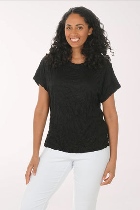 Woman wearing a black t-shirt and white pants on a white background
