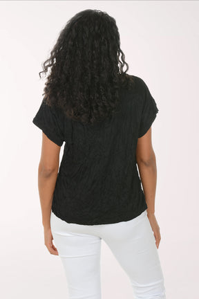 Woman wearing a black t-shirt and white pants on a white background