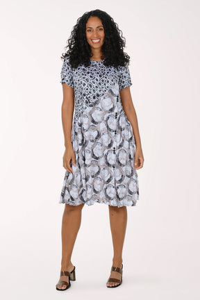 Woman wearing a patterned dress on a white background