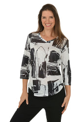 Woman wearing a black and white abstract patterned top on a white background.