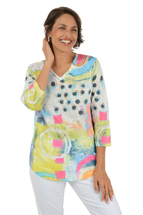 Woman wearing a colorful abstract patterned top on a white background. Second front shot.