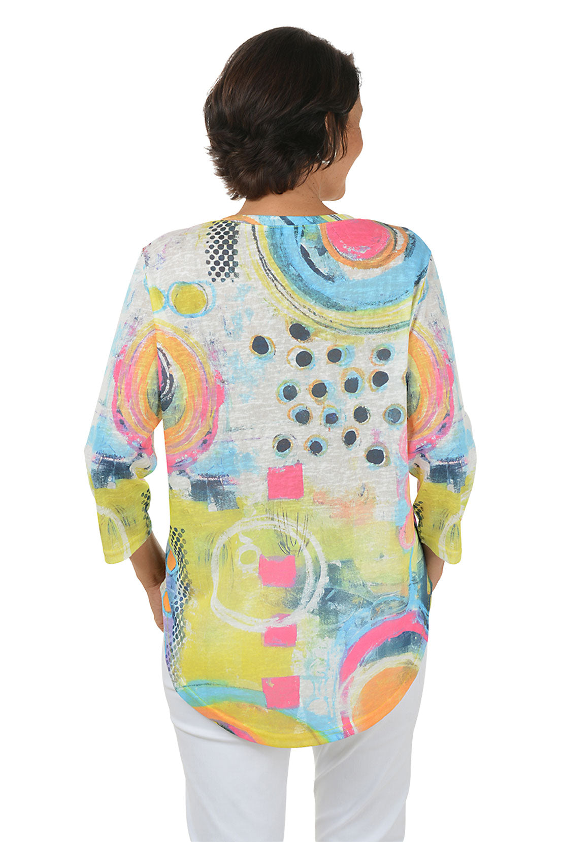 Woman wearing a colorful abstract patterned top on a white background. Back shot.