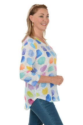 Woman wearing a colorful polka dot shirt on a white background