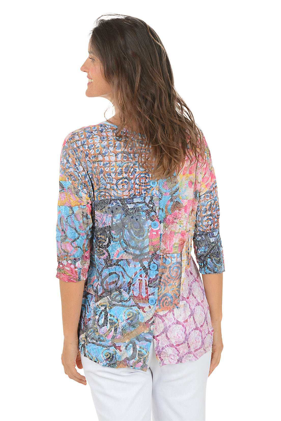 Woman wearing a colorful patterned top on a white background. Back shot.
