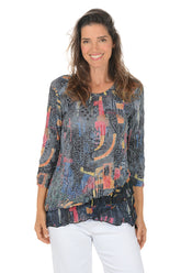 Woman wearing a patterned blouse with a white background.